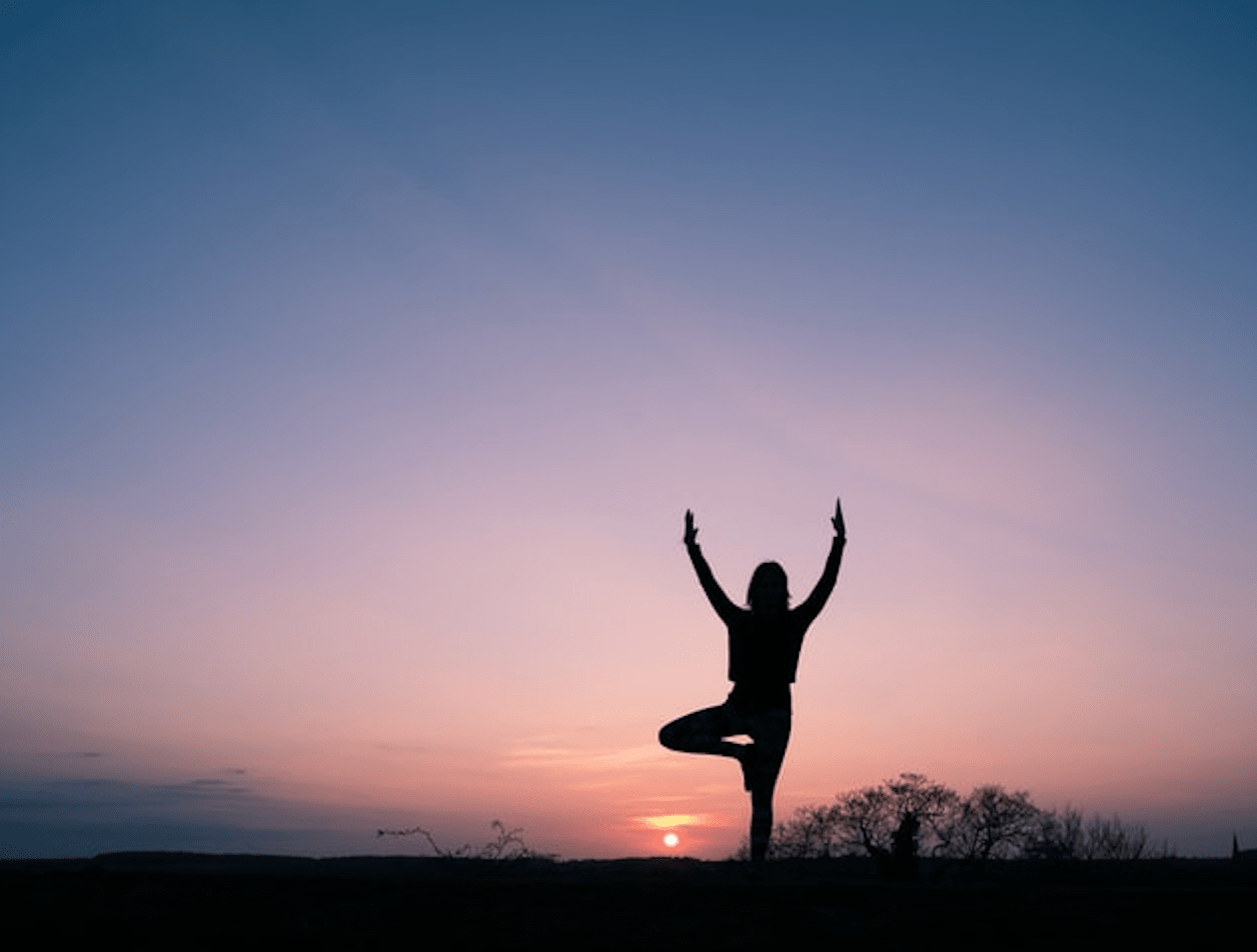 Woman doing yoga during a sunset