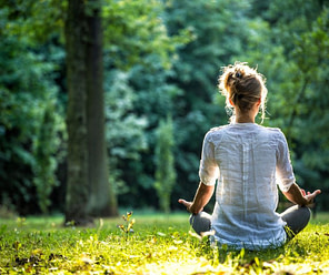 woman meditating in the woods