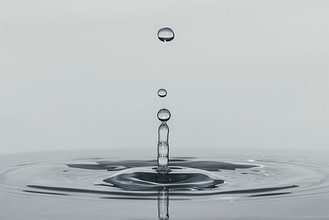 Slow motion image of a drip slashing in water.