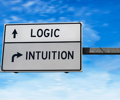 Sign that shows Logic with arrow one way and Intuition saying to go another way with sky in background