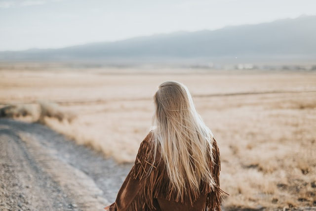 a lady walking alone in a beautiful mountains area.